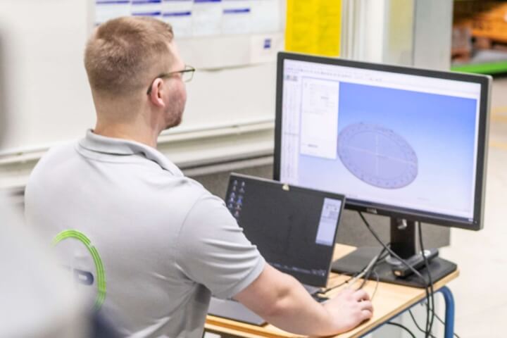 Mitarbeiter bereitet Bauteil per 3D-Modell für präzise Lasermessung vor.