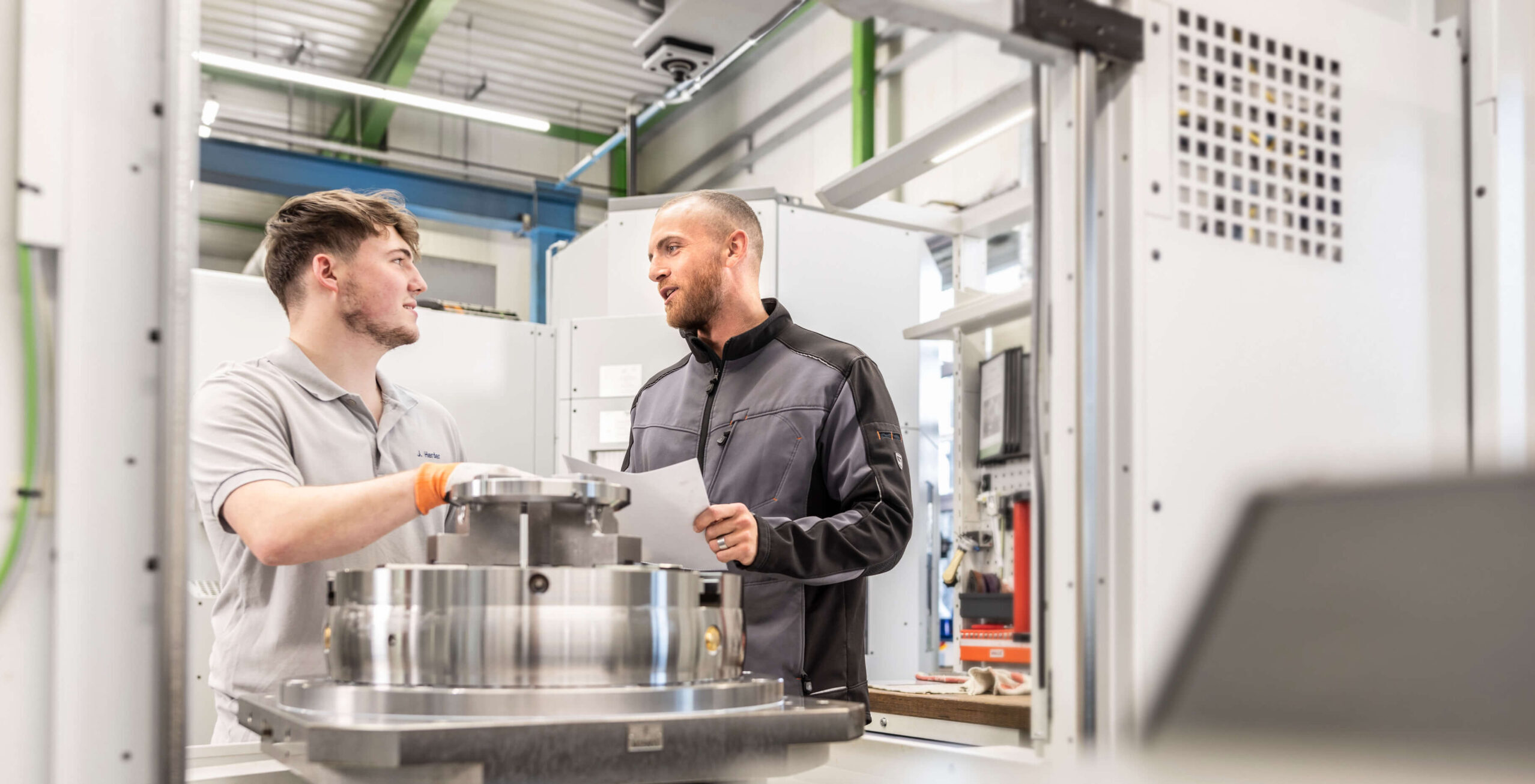 Zwei Mitarbeiter von HSP Components im Gespräch während der Produktion.
