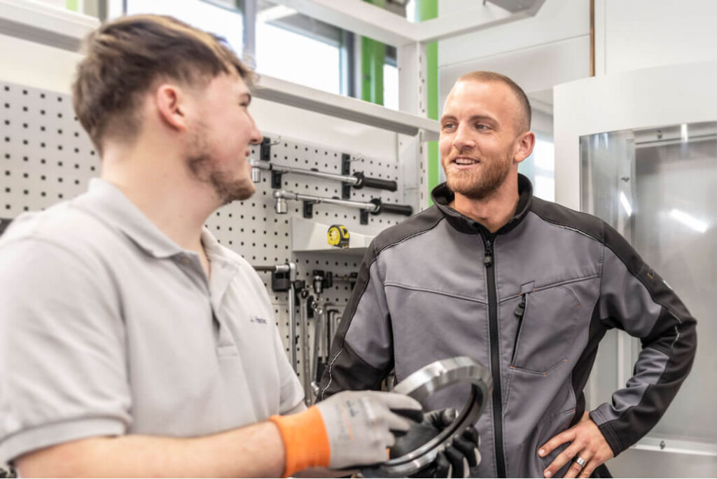 HSP Mitarbeiter in der Produktion im Gespräch sichern den Wissensaustausch.