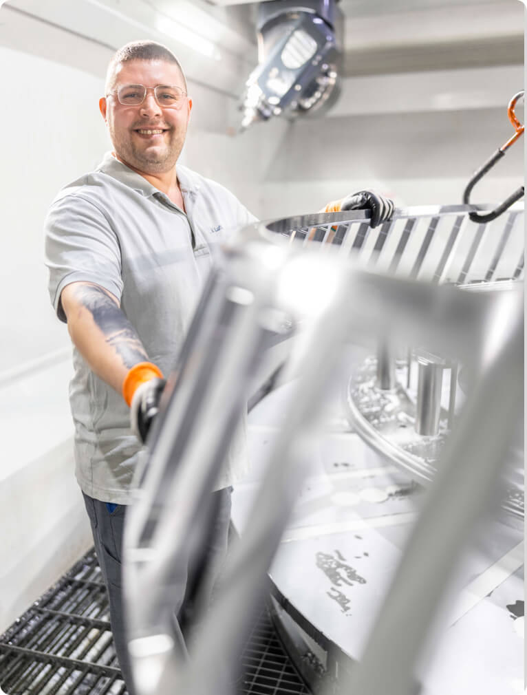 HSP Mitarbeiter auf den Rohling eines XXL Wälzlagerkäfig gestützt.