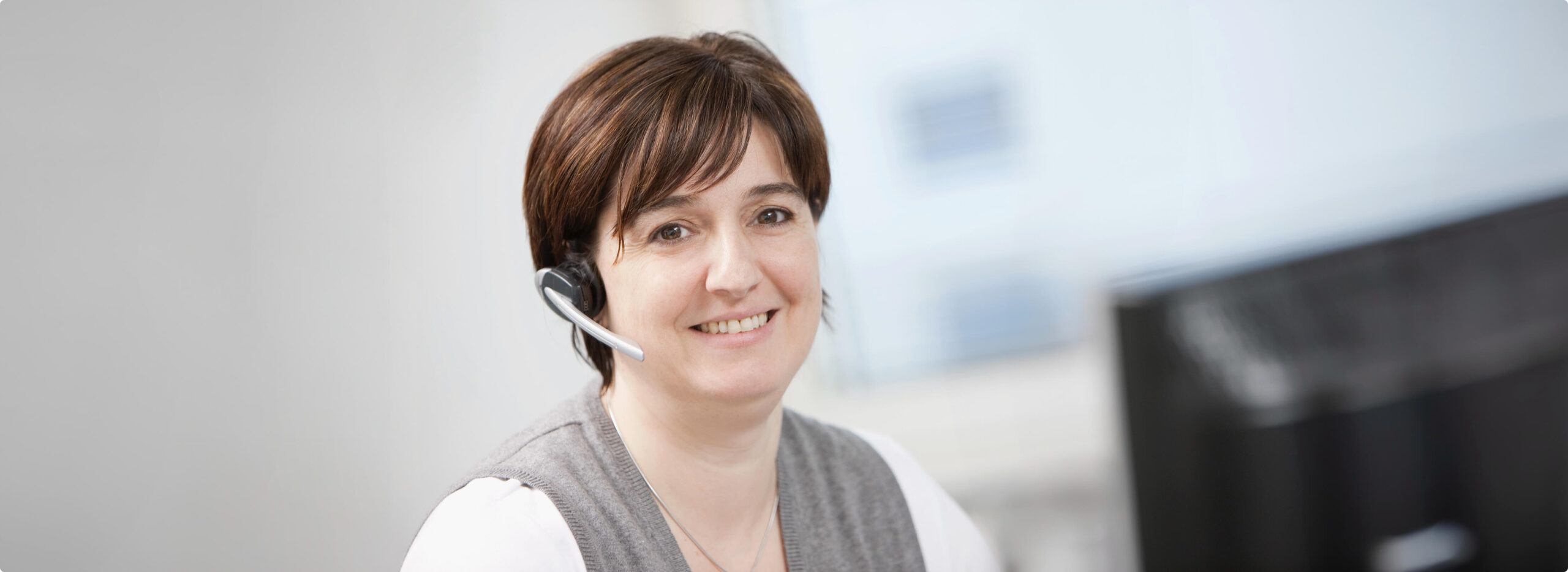 HSP Vertriebs-Mitarbeiterin am Computer mit Headset